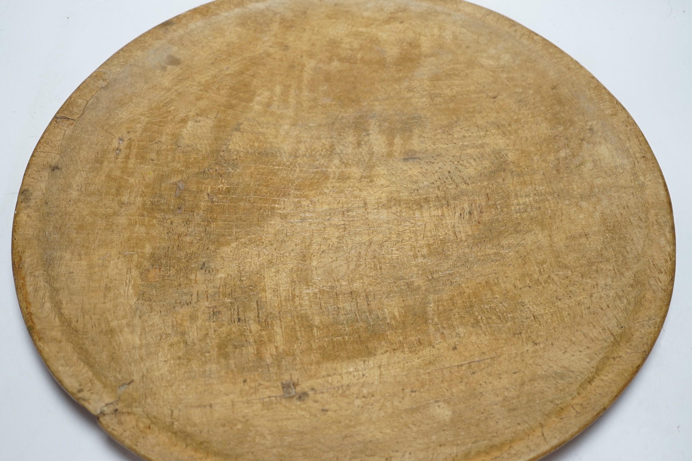 A large turned beech bowl of shallow form, 45cm in diameter